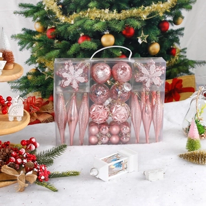Pink Christmas ornaments set with glitter snowflakes and plastic baubles in a clear gift box