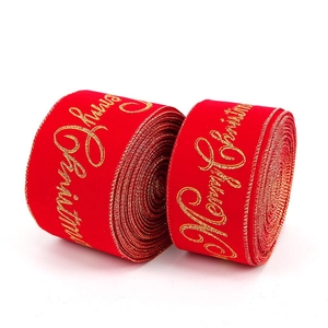 Vue macro de rubans en velours rouge avec impression dorée Joyeux Noël et bords filaires