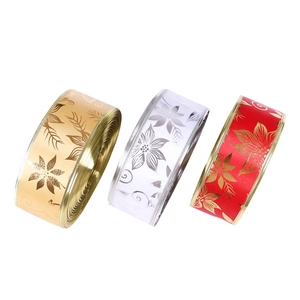Detail view of festive Christmas ribbons with gold poinsettia floral prints in three colors