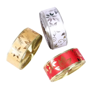 Detail of Christmas ribbons with gold floral prints in red, white and gold satin
