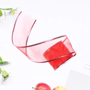 Detail of red translucent organza Christmas ribbon with delicate textured edges for DIY crafts