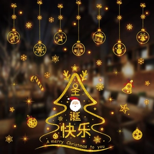 Detailed view of festive golden glitter Christmas window clings with Santa and snowflakes