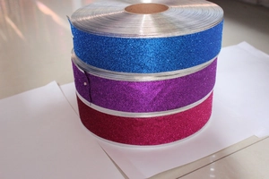 Close-up of blue, purple and rose red glitter ribbons with wired silver edges for DIY crafts