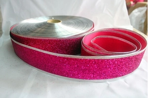 Macro view of rose red glitter ribbon with silver wire edges for Christmas gift wrapping