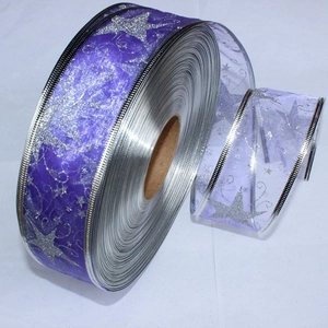 Close-up of purple sheer ribbon with silver star patterns and wired edges for shaping
