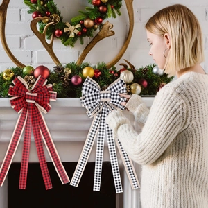 Detail of classic red and black plaid Christmas bow hung on a rustic stone fireplace mantle