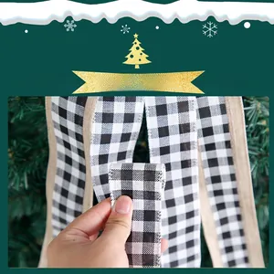 Detail of buffalo plaid Christmas ribbon with rustic burlap edges on a green tree