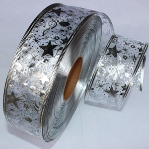 Close-up of silver glitter ribbon with music notes and stars for Christmas gift wrapping
