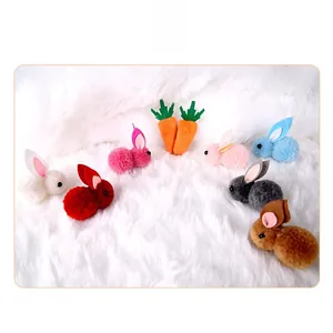 Detail view of colorful mini plush rabbits and carrots hair clip accessories on white fur