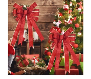Detail of red and gold Christmas tree topper bow with glitter finish and ribbon tails