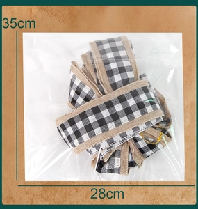 Detail view of black and white plaid Christmas bow in 35cm x 28cm plastic packaging
