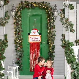 Plaque de porte de Noël avec Père Noël et franges rouges dans un décor de porche de maison