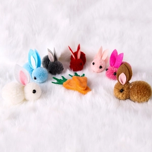 Colorful Easter bunny hair clips with pom-poms and felt carrots on white plush background