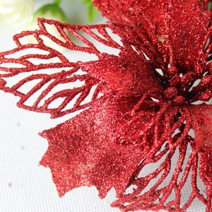 Macro shot of red glitter poinsettia flower with intricate hollowed-out petal textures