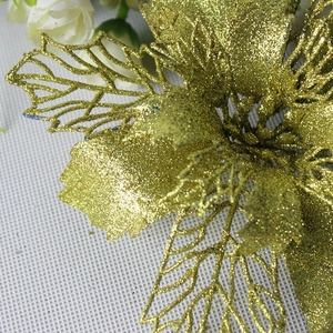 Close-up of golden glitter artificial flower with hollow petals for Christmas tree decoration