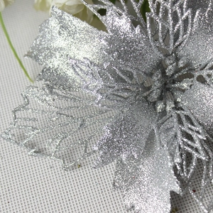Macro shot of silver artificial Christmas flower with hollow petals and glitter texture