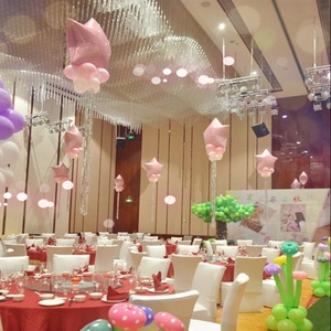 Pink star foil and pastel latex balloon arch setup for kids birthday party backdrop