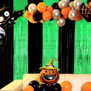Décor de fête d'Halloween avec rideaux de clinquant vert noir et ballons citrouille