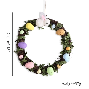 Easter wreath with colorful eggs, green leaves and a plush bunny on a natural twig ring