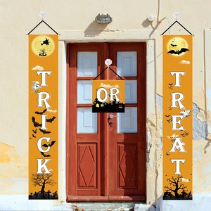 Close-up of Halloween porch banners featuring trick or treat silhouettes on a red wooden door