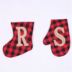 Detail of buffalo plaid Christmas stockings and mittens with rustic burlap letter appliques