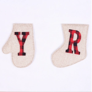 Macro view of Christmas burlap glove and boot bags with plaid letter patches Y and R
