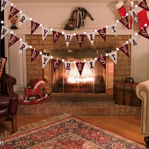 Close-up of rustic Merry Christmas banner with buffalo plaid flags on a warm fireplace