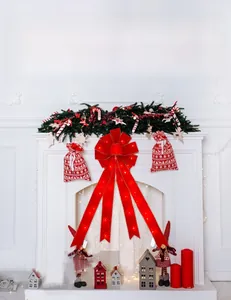 Détail d'un grand nœud de Noël rouge lumineux avec LED sur un décor de cheminée