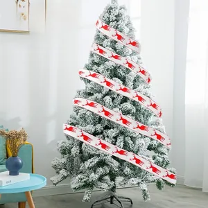 Close-up of white Christmas ribbon with red reindeer patterns on a decorated tree