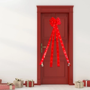 Détail d'un grand nœud de Noël rouge avec lumières LED et longs rubans festifs