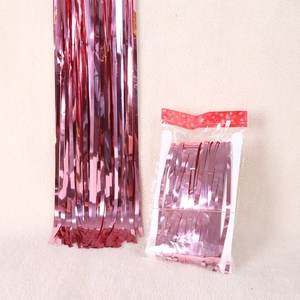 Close-up of rose gold fringe curtain backdrop with metallic finish in original packaging