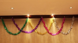Macro detail of multicolored 2m Christmas tinsel garlands hanging in festive waves