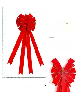 Detailed close-up of large velvet red Christmas bow with gold trim and long streamers