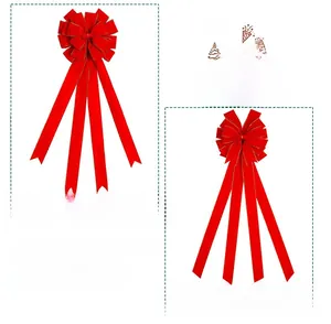 Detail of red velvet Christmas bows with gold edges featuring long hanging ribbons