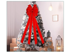 Detail of red velvet Christmas bow with gold trim used as a decorative holiday tree topper