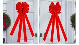 Detailed view of red velvet Christmas bow with gold edges on white door decor