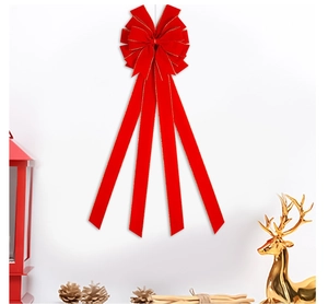 Detail of red velvet Christmas bow with gold edges and long ribbons for tree decor