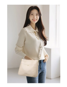 Detail of off-white lychee leather crossbody bag with geometric woven shoulder strap
