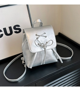 Close-up of silver PU leather mini backpack featuring flap cover and bow knot details