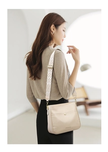 Detail of beige pebbled leather crossbody bag with ethnic style jacquard wide strap