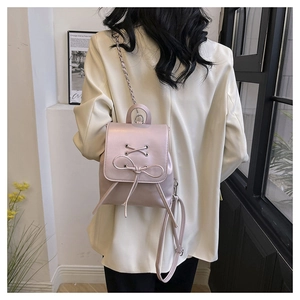 Pink PU leather mini backpack featuring elegant bow lace-up detail and metal chain strap
