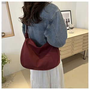 Detail of burgundy large capacity tote bag showing natural drape and hobo style on shoulder