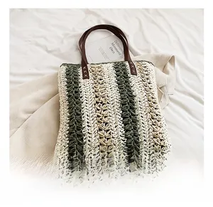Detailed close-up of woven paper straw texture with green stripes and leather handle