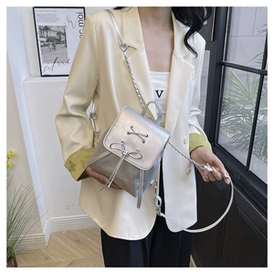 Detail of silver metallic PU mini backpack with bow decoration and chain strap