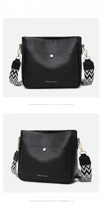 Detail of black pebbled leather crossbody bag featuring geometric wide shoulder strap