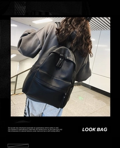 Close-up of black litchi pattern PU leather backpack with secure zipper and adjustable straps