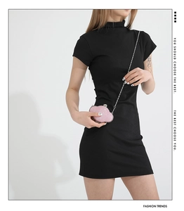 Pink cloud-shaped crossbody bag with glitter finish and silver chain on black dress