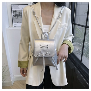 Detailed macro of a silver PU leather mini backpack featuring chic metallic chain straps