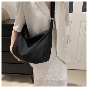 Detail view of the black nylon hobo bag featuring wide shoulder straps and large capacity