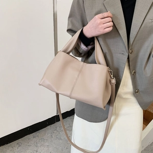 Minimalist beige PU leather tote bag for women shown with a stylish casual outfit